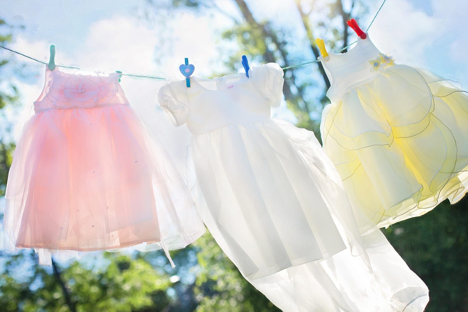 Children's dresses drying on a line in bright sunlight